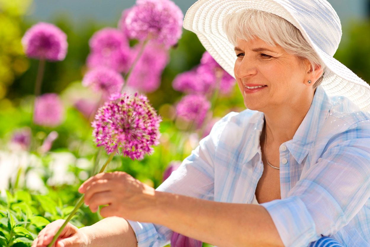 Mevrouw plukt bloemen in de tuin
